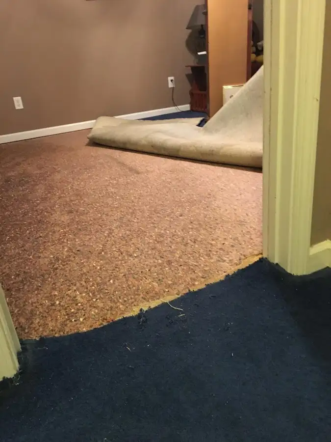 Carpet pad removal revealing water damage during Water Mitigation Services in Navarre